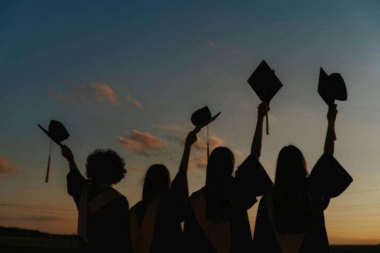 Silhouette of People Raising Their Graduation Hats