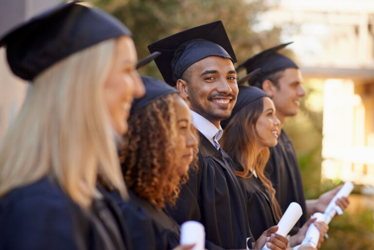 Graduating students in regalia, standing in a line.